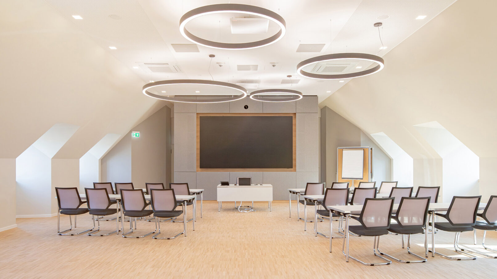 Seminarraum Hotel Schloss Montabaur mit großformatigem Präsentationsmonitor, Akustikdecke und Ringpendelleuchten