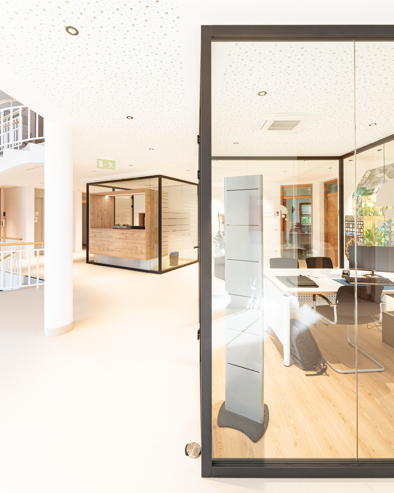 Eingangsbereich RH Wasser Dörth mit Empfangskubus und verglastem Besprechungsraum im Vordergrund