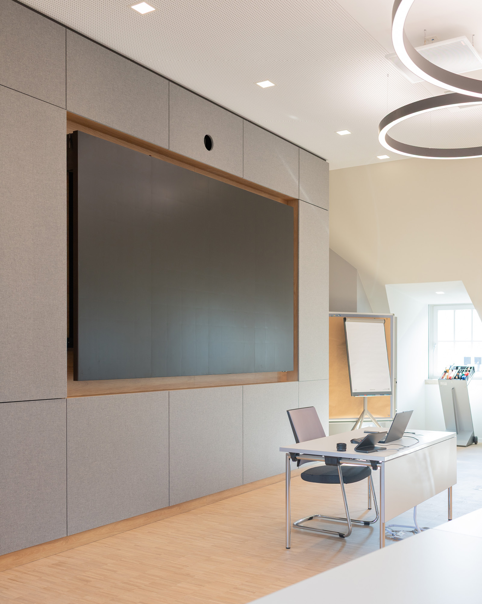 Seminarraum Hotel Schloss Montabaur mit integrierter Medienwand, Akustikverkleidung und Ringpendelleuchten