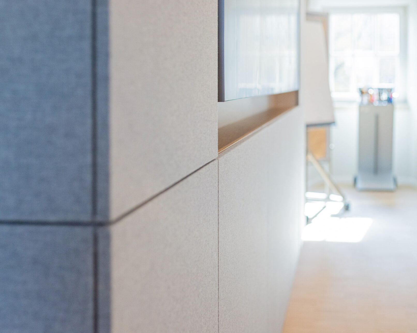 Detail Akustikwand im Seminarraum Hotel Schloss Montabaur mit stoffbespannten Wandpaneelen und integrierter Präsentationsfläche